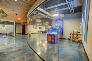 Curved Glass Walls with Basketball Game behind